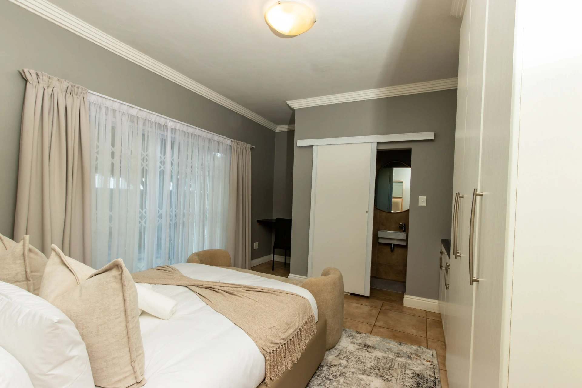 The Horizon Room — bed with sheer drapery and en-suite